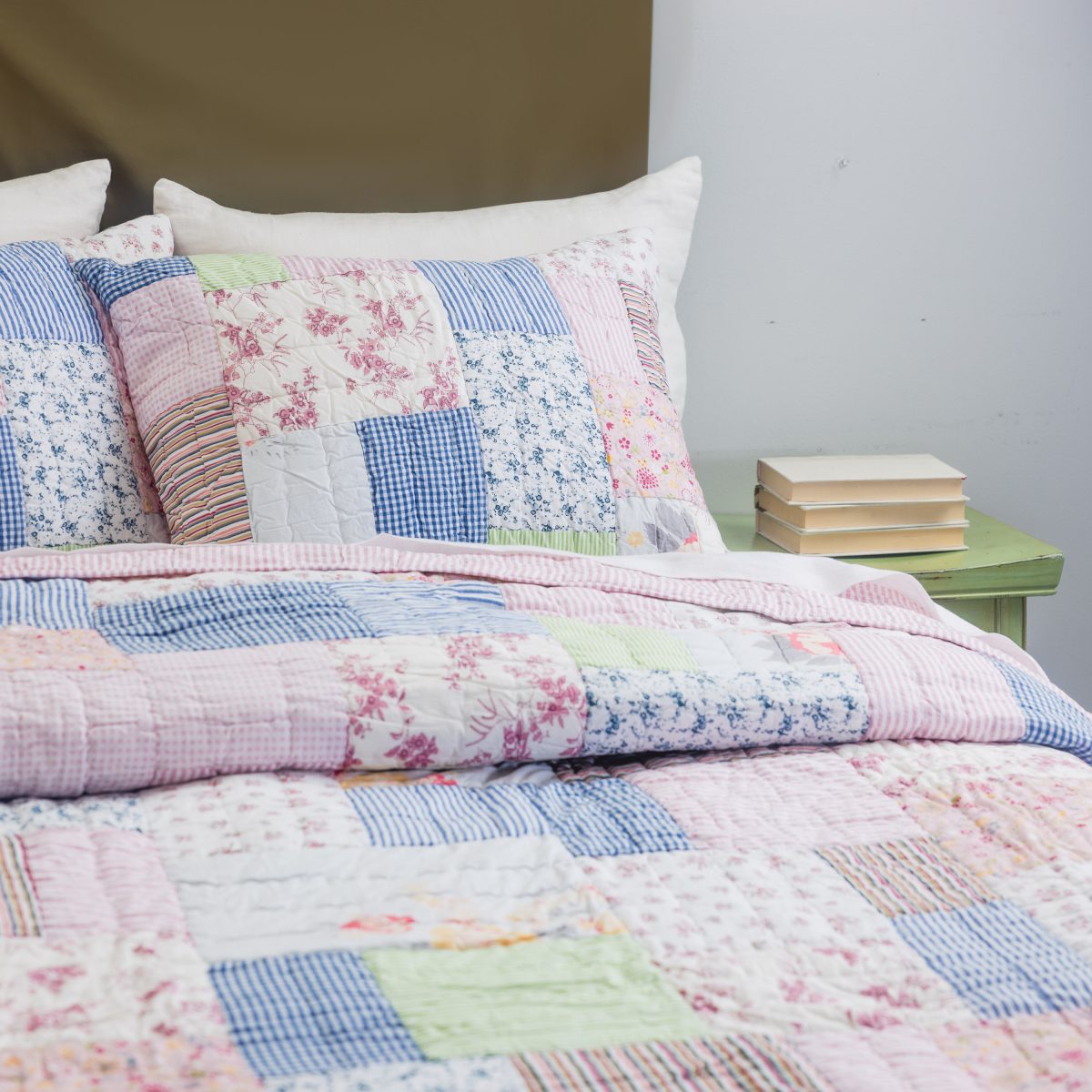 Amity home lattice patchwork quilt set   charming floral striped and gingham patterns in pink blue and white on a bed