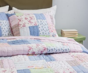 Amity home lattice patchwork quilt set   charming floral striped and gingham patterns in pink blue and white on a bed
