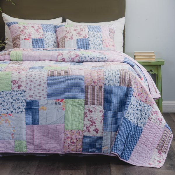 Amity Home Lattice Patchwork Quilt Set - a cozy bed with a quilt and two pillows featuring various floral, striped, and gingham patterns in pink, blue, green, and white.