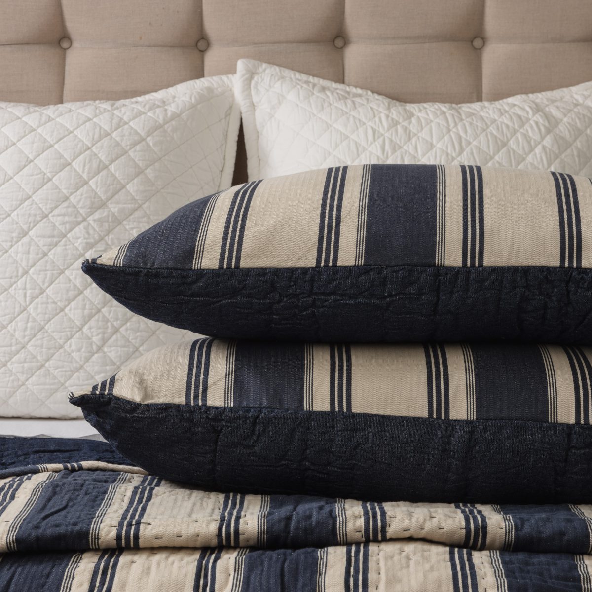 Amity home camden quilt   blue and natural striped quilt with kantha stitching displayed on a bed with matching shams