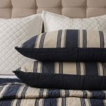 Amity home camden quilt   blue and natural striped quilt with kantha stitching displayed on a bed with matching shams