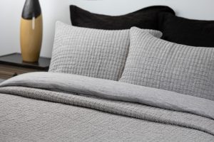 Amity home catalina linen quilt   grey chambray quilt and matching pillows with a textured puckered pattern on a bed