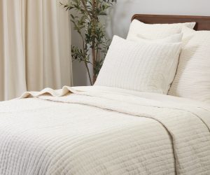 Amity home ethan quilt in ivory featuring a soft textured linear stitch pattern styled on a bed with matching pillows