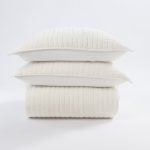 Amity home ethan quilt and two matching pillows in ivory stacked on a white background showing vertical channel stitching