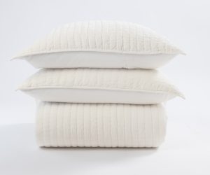 Amity home ethan quilt and two matching pillows in ivory stacked on a white background showing vertical channel stitching