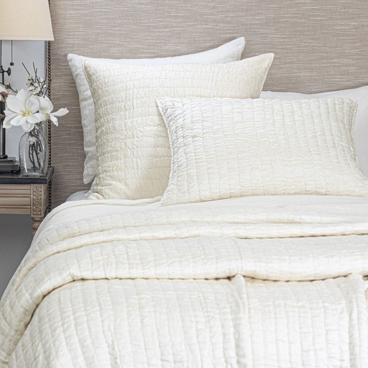 Amity home hadon quilt   ivory luxury bedding with a distinctive crinkled texture draped over a bed with matching pillows