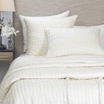 Amity home hadon quilt   ivory luxury bedding with a distinctive crinkled texture draped over a bed with matching pillows