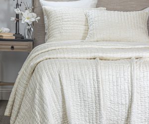 Amity home hadon quilt   ivory textured quilt with puckered square pattern draped over a bed with matching shams