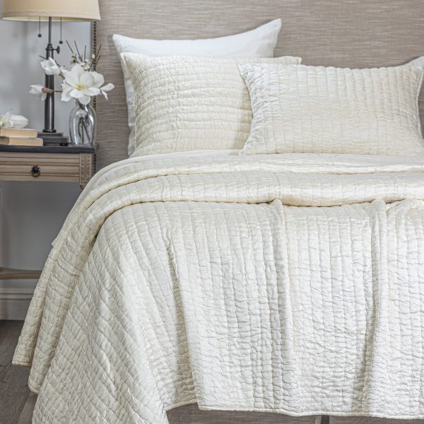 Amity Home Hadon Quilt - Ivory textured quilt with puckered square pattern draped over a bed with matching shams.