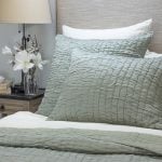 Amity home hadon quilt in seaglass featuring a unique textured quilted pattern styled on a bed with matching pillows