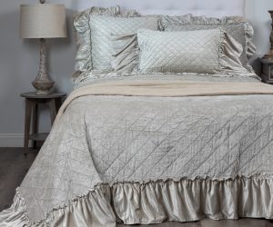 Amity home estrella quilt   oyster luxury quilt with diamond stitching and ruffled edge made from a soft shimmering fabric styled on a bed