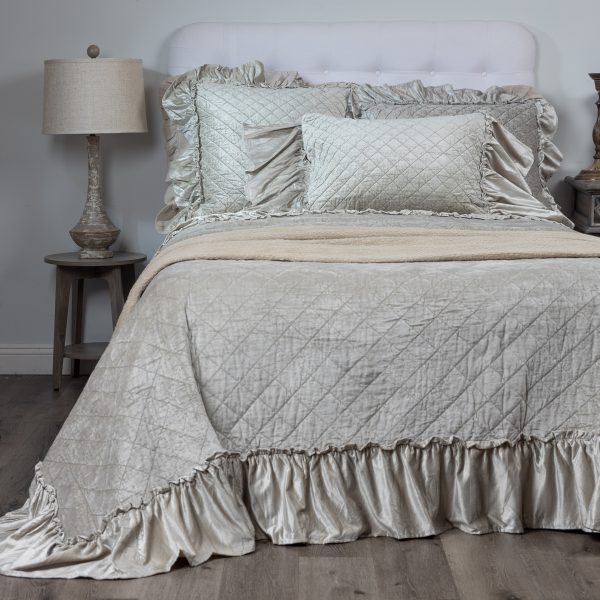 Amity Home Estrella Quilt - Oyster luxury quilt with diamond stitching and ruffled edge, made from a soft, shimmering fabric, styled on a bed.