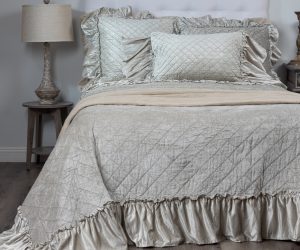 Amity home estrella quilt   oyster luxury quilt with diamond stitching and ruffled edge made from a soft shimmering fabric styled on a bed