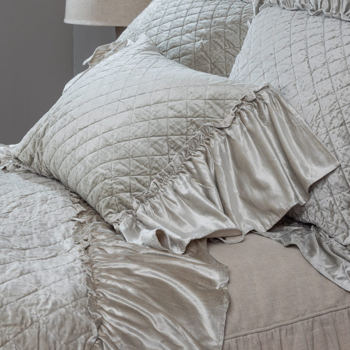 Amity home estrella quilt   oyster velvet quilt and ruffled pillow sham with diamond quilting styled on a bed