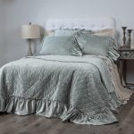 Amity home estrella quilt   sea glass velvet quilt with diamond quilting and ruffled edges styled on a bed with matching pillows