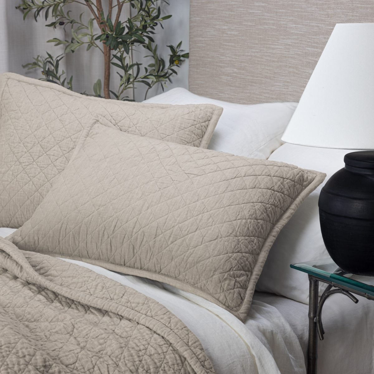 Amity home linen quilt in natural beige with diamond quilting styled on a bed with matching pillows and white sheets