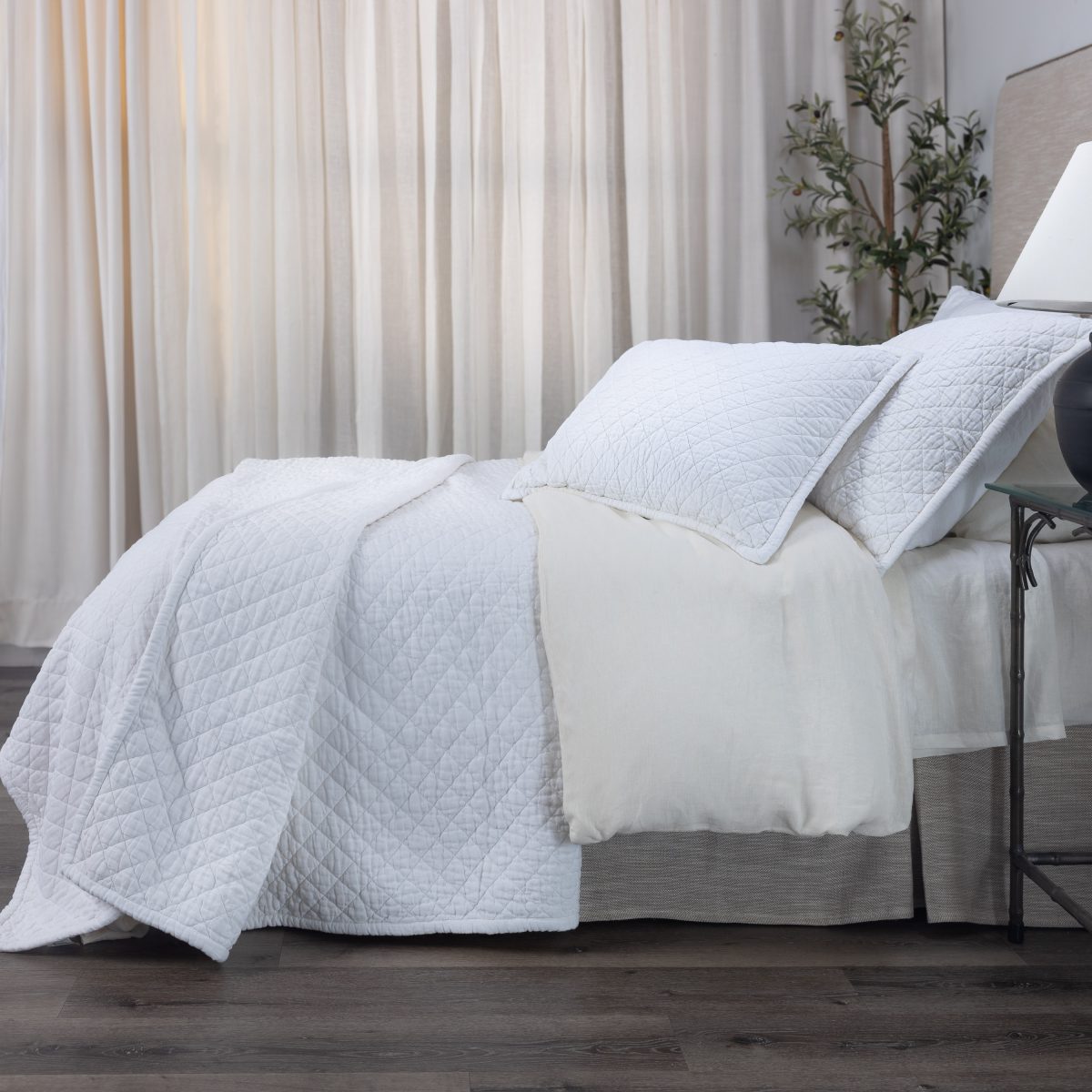 Amity home dale linen quilt in white featuring a subtle diamond quilting pattern draped on a styled bed with matching shams