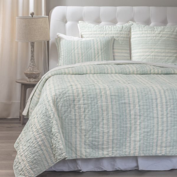 Amity Home Aiden Quilt - Seaglass and cream striped quilt and shams on a bed with a white headboard, showing soft quilted texture.