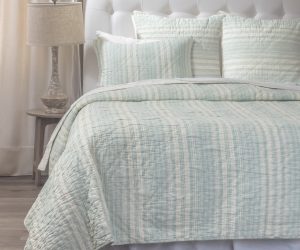 Amity home aiden quilt   seaglass and cream striped quilt and shams on a bed with a white headboard showing soft quilted texture