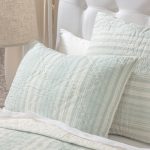 Amity home aiden quilt in seaglass and cream stripes with a soft quilted texture styled on a bed