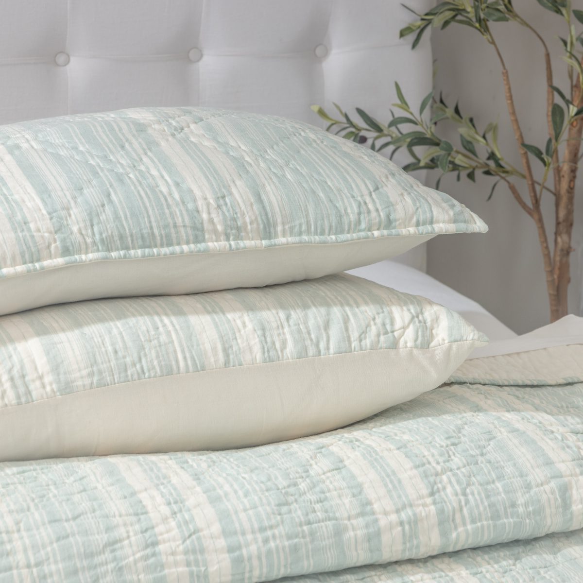 Amity home aiden quilt   seaglass and cream striped soft quilted texture Shown on a bed with matching pillows