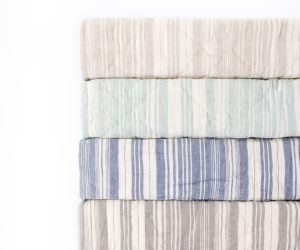 Amity home aiden quilts   stack of four folded striped quilts in natural mint blue and grey with a soft quilted texture