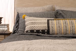 Amity home bina x long bolster in cream  black   geometric weave  yellow pom poms