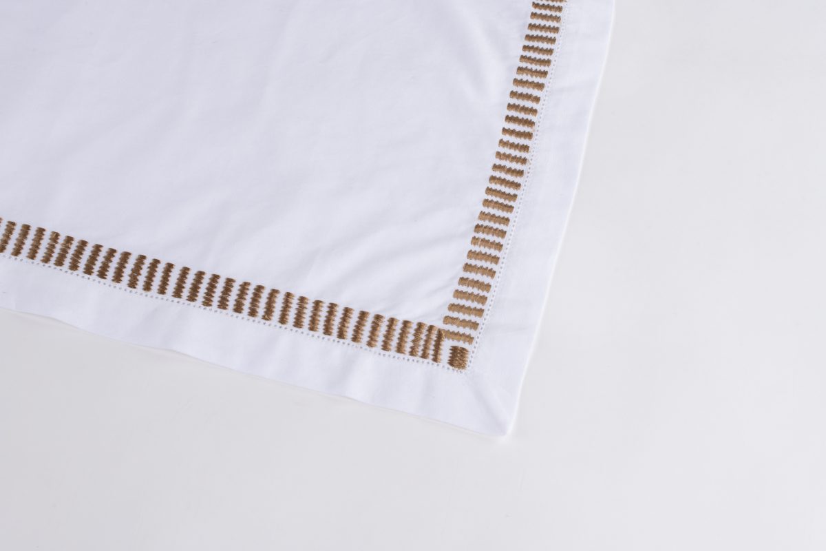 Amity home savona table runner in white with caramel   dash embroidered border
