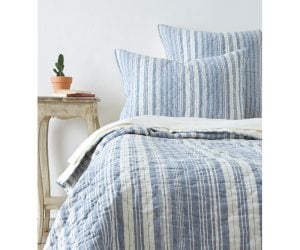 Amity home aiden quilt   blue and white striped quilt with quilted texture styled on a bed with matching pillows
