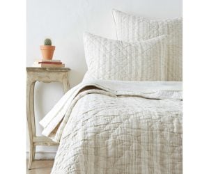 Amity home aiden quilt   natural beige and off white striped quilt with diamond quilting draped on a bed with matching shams