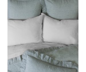 Amity home basillo duvet cover in sea glass featuring ruffled edges and soft texture styled on a bed with matching shams