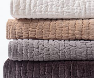 Amity home ethan quilt   stack of four rolled quilts in khaki cream grey and dark brown with a plush crinkled texture