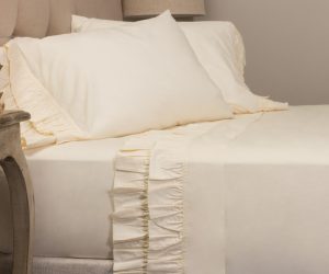 Amity home french ruffle sheet set in ivory styled on a bed with ruffled pillowcases and flat sheet hem