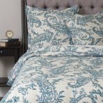 Amity home kiera duvet cover   turquoise paisley pattern on cream luxury bedding styled on a bed with a tufted headboard