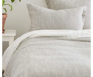 Amity home logan duvet cover   grey herringbone textured linen blend bedding on a styled bed with matching pillow shams