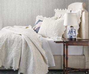 Amity home shantoon quilt   vanilla luxury quilt with intricate floral quilting and scalloped edges draped on a styled bed