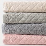 Amity home simona rayon velvet quilt   stack of four diamond quilted quilts in ivory light grey dark grey and pink showing soft velvet texture