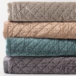 Amity home simona rayon velvet quilt   stack of four folded quilts showing soft velvet texture and diamond quilting in multiple colors