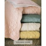 Amity home tudor quilt   gold luxury bedding with intricate quilted pattern folded in a stack of colorful quilts